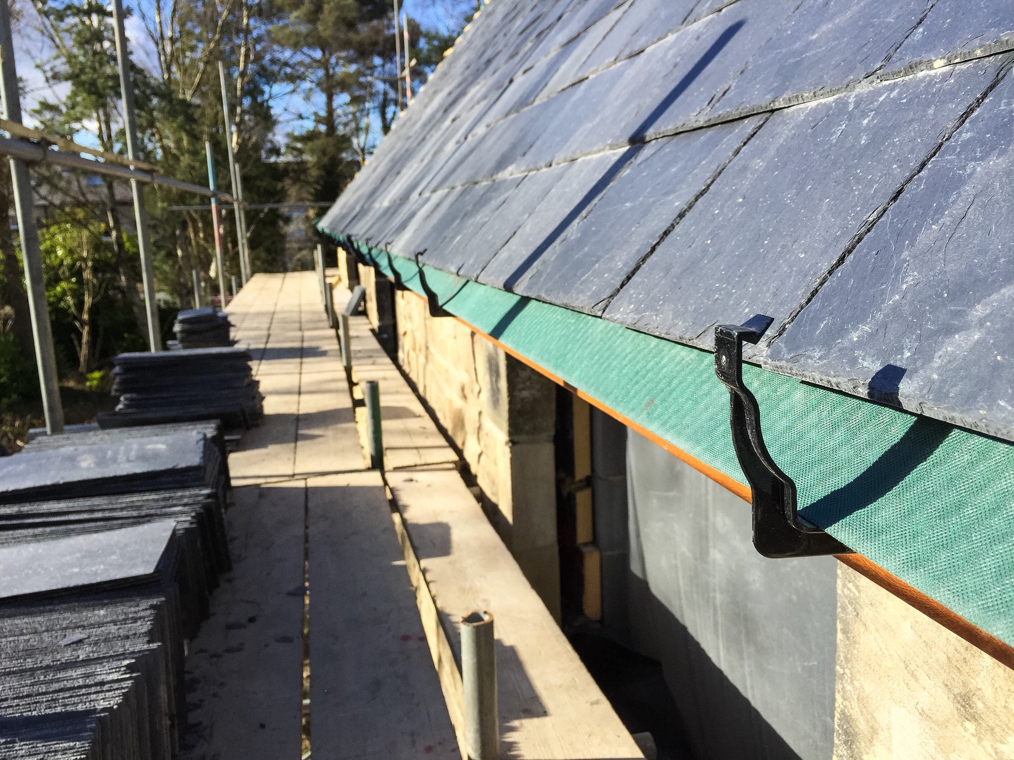 Guttering clips being installed off scaffolding on a new build property